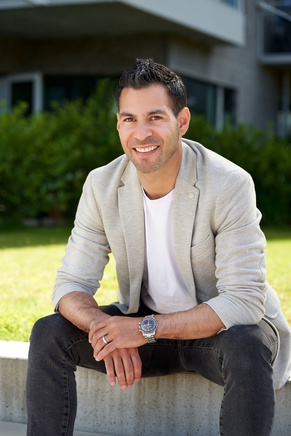 Man sidder i sin blæser og smiler.